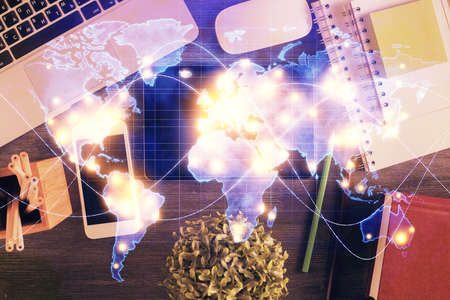 Double exposure of business theme hologram over desktop with phone. Top view. Mobile international...