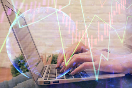 Double exposure of woman hands typing on computer and forex chart hologram drawing. Stock market analysis concept.の写真素材