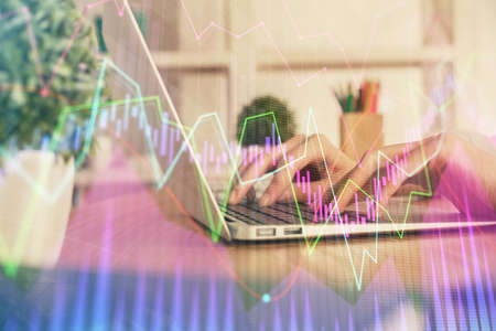 Double exposure of woman hands typing on computer and forex chart hologram drawing. Stock market...