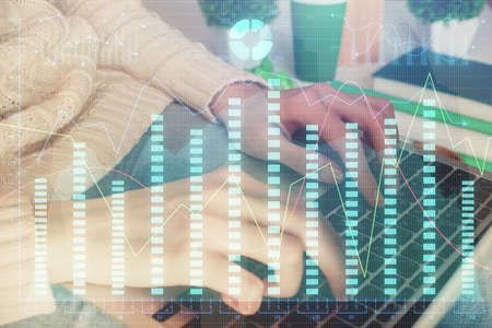 Double exposure of woman hands typing on computer and forex chart hologram drawing. Stock market...