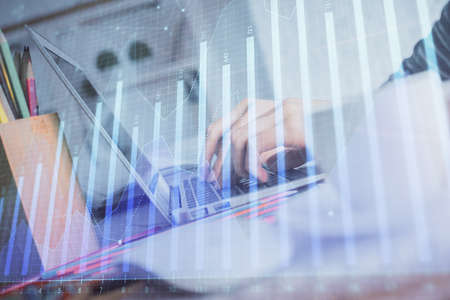 Double exposure of woman hands typing on computer and forex chart hologram drawing. Stock market...