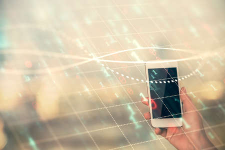 Double exposure of forex chart sketch hologram and woman holding and using a mobile device. Stock...