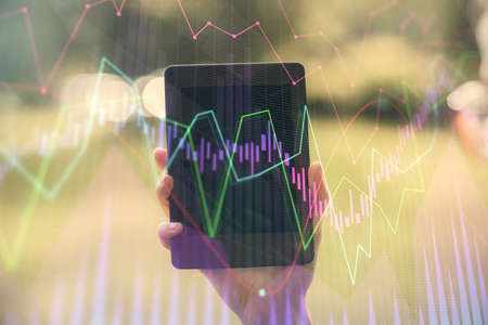 Double exposure of forex chart sketch hologram and woman holding and using a mobile device. Financial market concept.の写真素材