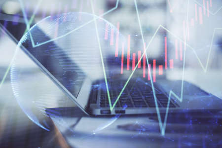 Forex graph hologram on table with computer background. Double exposure. Concept of financial...