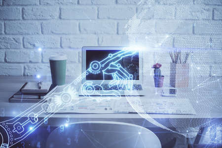 Computer on desktop in office with technology theme hologram. Double exposure. Tech concept.