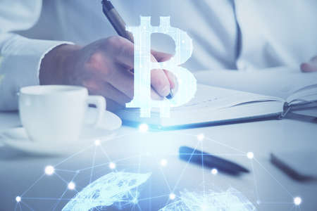 Mans hands working with notes background. Cryptocurrency and finance concept. Double exposure.