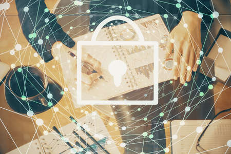 Double exposure of hands making notes with lock icons. Concept security and protection of dataの写真素材