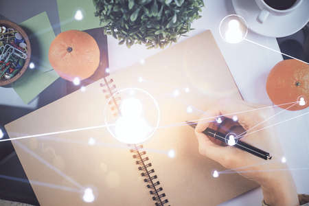 Social network theme hologram over hands taking notes background. Concept of global international...