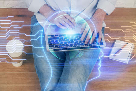 Businessman with computer background with brain theme hologram. Concept of brainstorm. Multi...