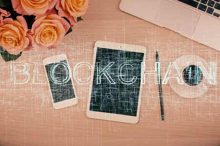 Double exposure of blockchain theme hologram over table with phone. Top view. Crypto technology concept.の写真素材
