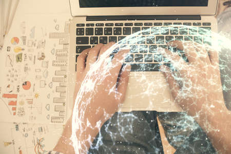 Double exposure of mans hands typing over computer keyboard and social network theme hologram drawing. Top view. People connection web concept.の写真素材