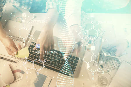 Double exposure of man and woman working together and DNA hologram drawing. Computer background. Medical education concept. Top View.の写真素材