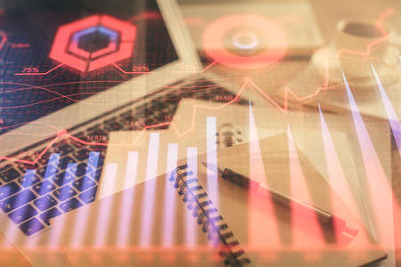 Double exposure of financial chart drawing and desktop with coffee and items on table background. Concept of forex market tradingの写真素材