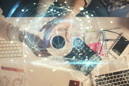 Double exposure of man and woman working together and social network theme hologram drawing. Computer background. connecting concept. Top View.の写真素材