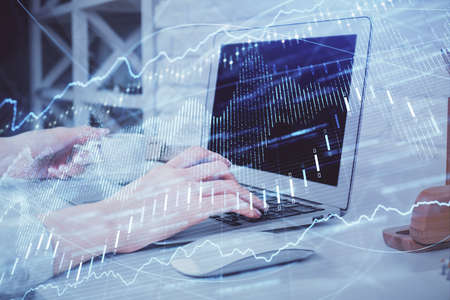 Multi exposure of woman hands typing on computer and forex chart hologram drawing. Stock market...