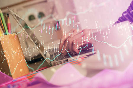 Double exposure of woman hands typing on computer and forex chart hologram drawing. Stock market...