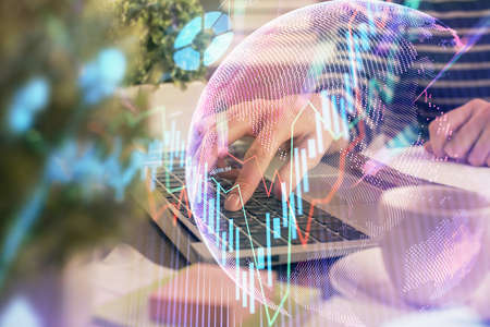 Double exposure of woman hands typing on computer and forex chart hologram drawing. Stock market invest concept.の写真素材