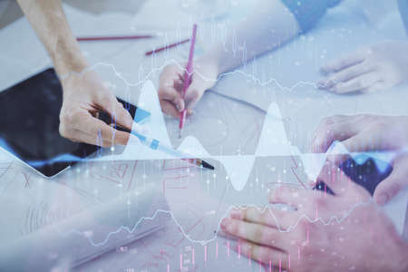 Double exposure of forex graph drawing and man and woman working together holding and using a mobile...