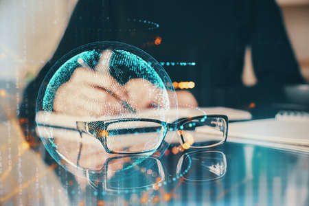 Double exposure of hands making notes with world map hologram and data theme icons. Concept of global computer data.の写真素材