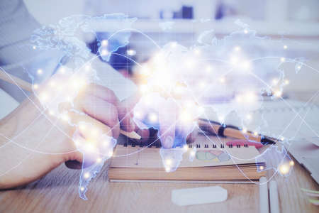 Double exposure of hands and notepad with business icons. Concept of international business.
