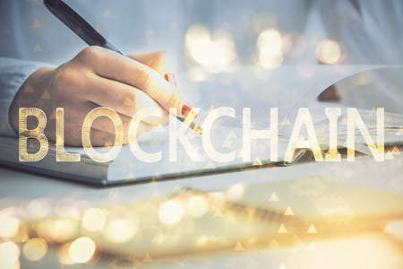 Cryptocurrency hologram over womans hands writing background. Concept of blockchain. Double exposureの写真素材