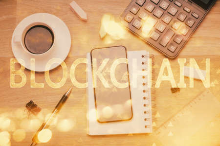 Double exposure of blockchain theme hologram over table with phone. Top view. Crypto technology concept.の写真素材