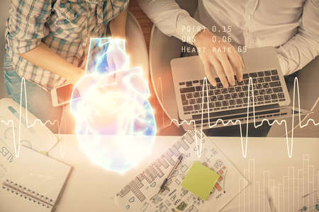 Double exposure of man and woman working together and heart hologram drawing. Computer background....