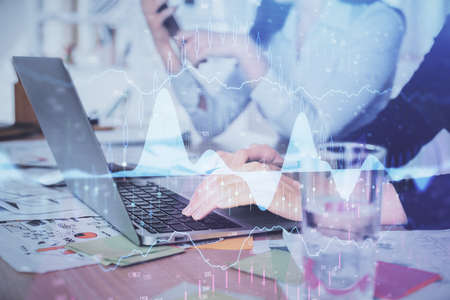 Multi exposure of woman hands typing on computer and forex chart hologram drawing. Stock market...