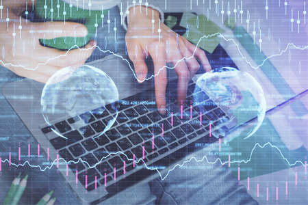 Double exposure of woman hands typing on computer and forex chart hologram drawing. Stock market...
