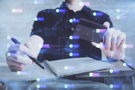 Double exposure of man hands holding a credit card and data theme drawing. E-commerce and technology...