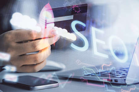 Double exposure of woman on-line shopping holding a credit card and SEO hologram drawing. Search...