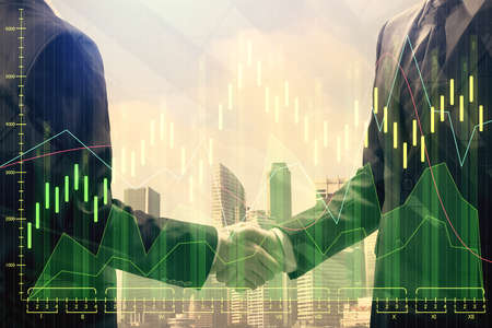 Double exposure of forex graph hologram and handshake of two men. Stock market concept.の写真素材