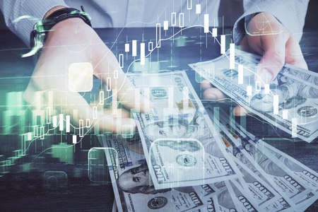Multi exposure of financial graph drawing hologram and USA dollars bills and man hands. Analysis...