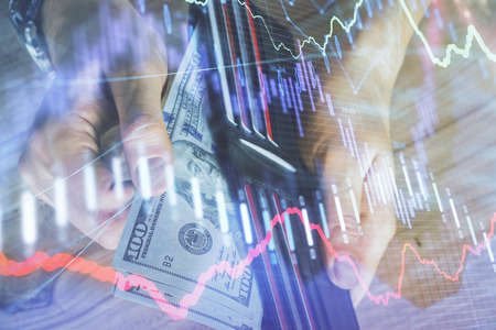 Multi exposure of forex graph drawing hologram and USA dollars bills and man hands. Technical...