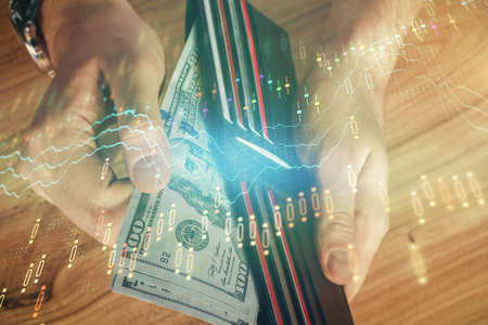 Multi exposure of forex graph drawing hologram and USA dollars bills and man hands. Technical...
