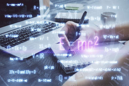 Science formula hologram over womans hands taking notes background. Concept of study. Double exposureの写真素材