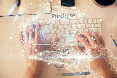Double exposure of man's hands typing over computer keyboard and social network theme hologram...