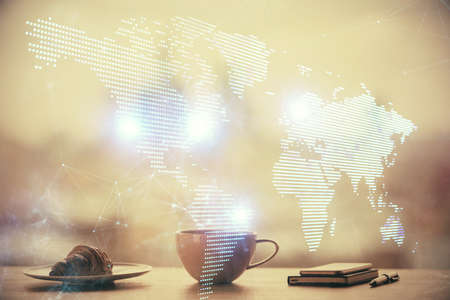 Double exposure of social network theme drawing hologram over coffee cup background in office....