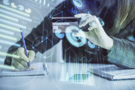 Double exposure of woman on-line shopping holding a credit card and data theme hologram drawing....