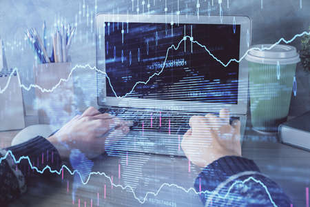 Double exposure of woman hands typing on computer and forex chart hologram drawing. Stock market...