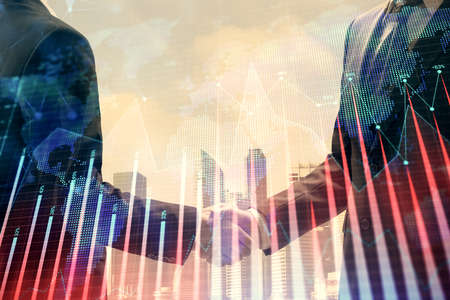 Double exposure of forex graph hologram and handshake of two men. Stock market concept.の写真素材