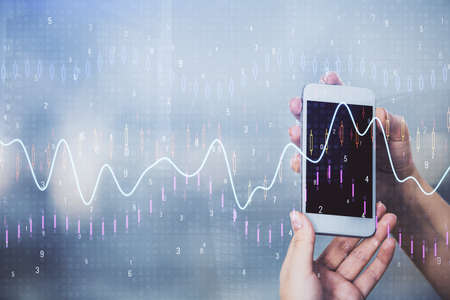 Double exposure of forex graph sketch hologram and woman holding and using a mobile device. Stock...