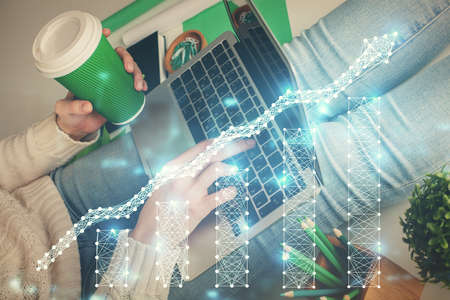 Double exposure of woman hands typing on computer and forex chart hologram drawing. Stock market...