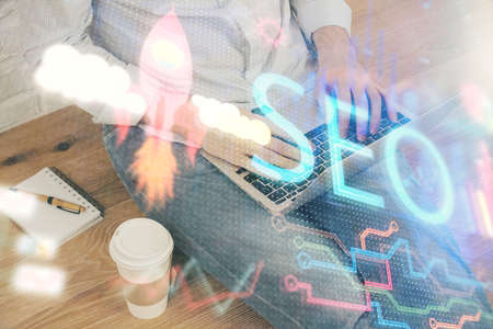 Multi exposure of seo icon with man working on computer on background. Concept of search engine...
