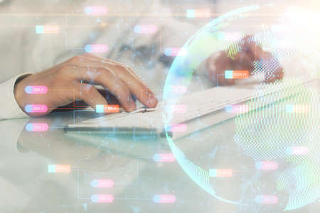 Double exposure of world map hologram with man working on computer on background. Concept of worldwideweb.の写真素材