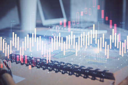 Double exposure of financial graph drawings and desk with open notebook background. Concept of forex...