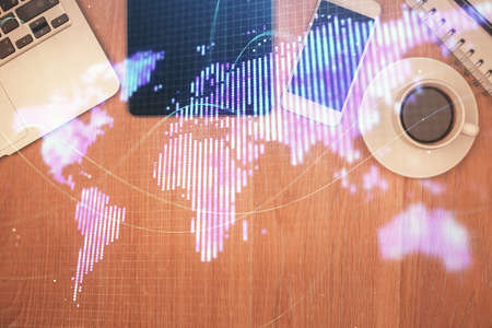 Double exposure of business theme hologram over desktop with phone. Top view. Mobile international...
