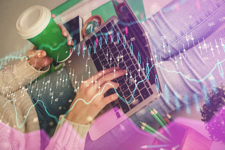 Double exposure of woman hands typing on computer and forex chart hologram drawing. Stock market...