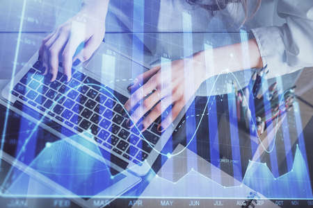 Double exposure of woman hands typing on computer and forex chart hologram drawing. Stock market...