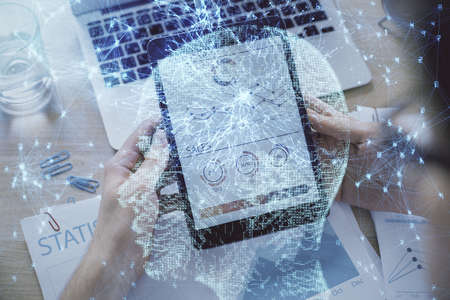 Double exposure of mans hand holding and using a digital device and brain hologram drawing. Data...